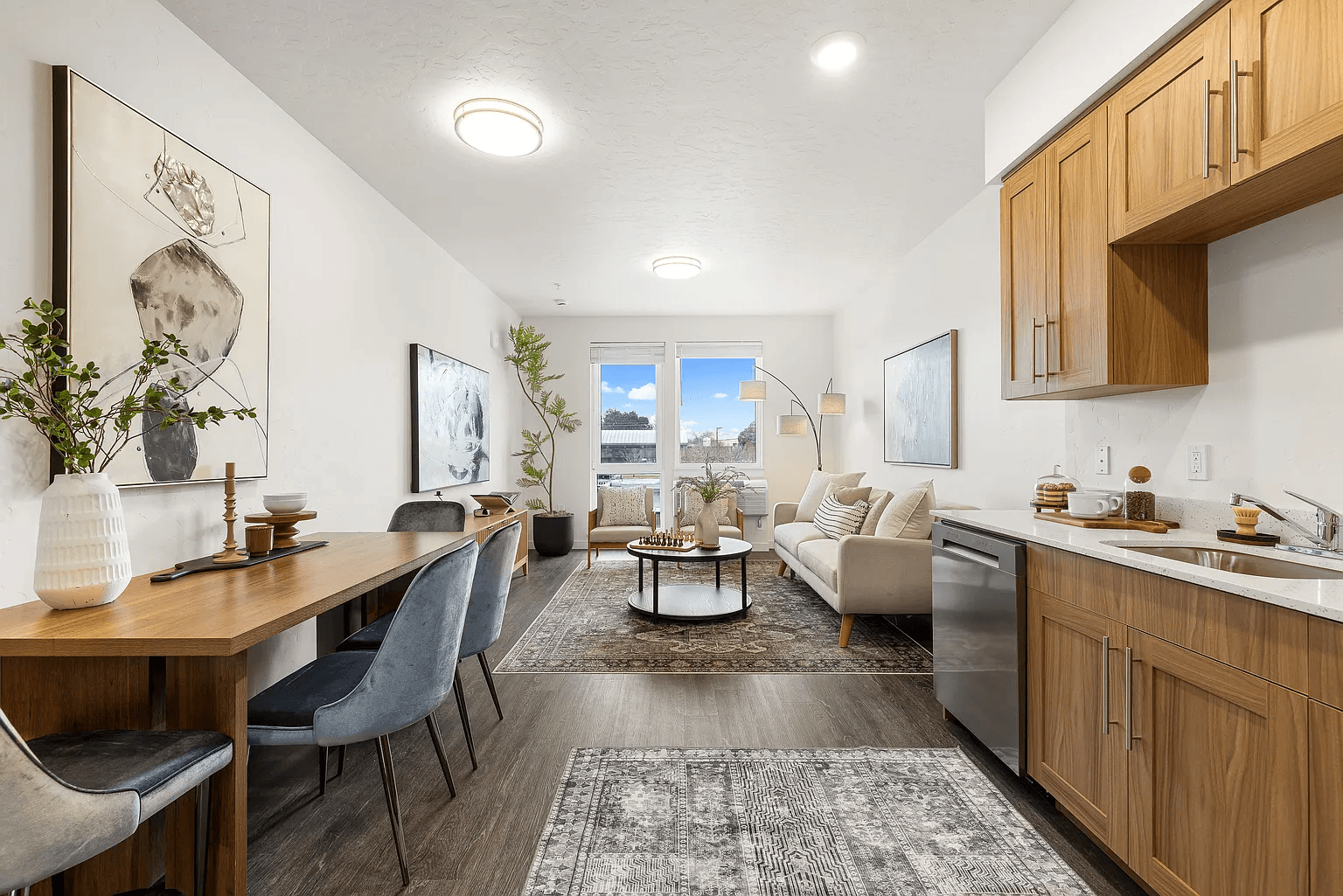 A modern kitchen and dining area with wooden furniture and a large window.